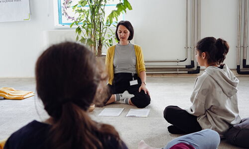 Hier sieht man Frauen und Mädchen beim Meditieren