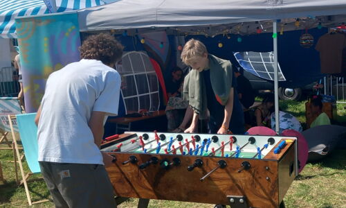 Junge Burschen spielen Tischfußball im Freien