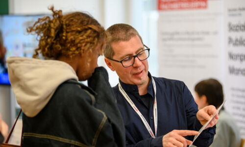 Ein Mann berät eine junge Frau bei der Connect Karrieremesse Sozialwirtschaft 2025