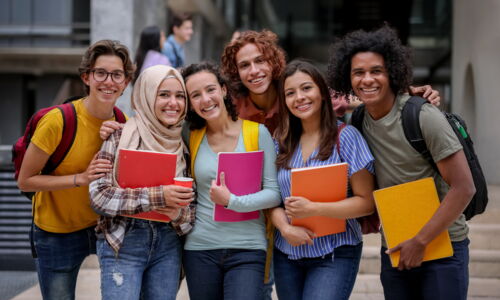 Das ist ein Gruppenfoto im Freien von jungen Erwachsenen mit Lernunterlagen