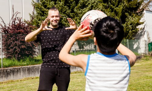 Junger Mann und Kind spielen Ball