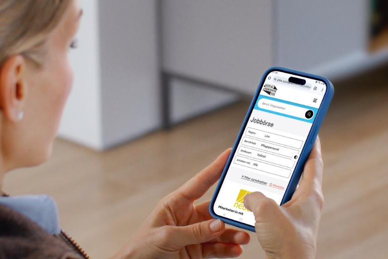Frau sucht am Smartphone in der Sozial-Jobbörse OÖ